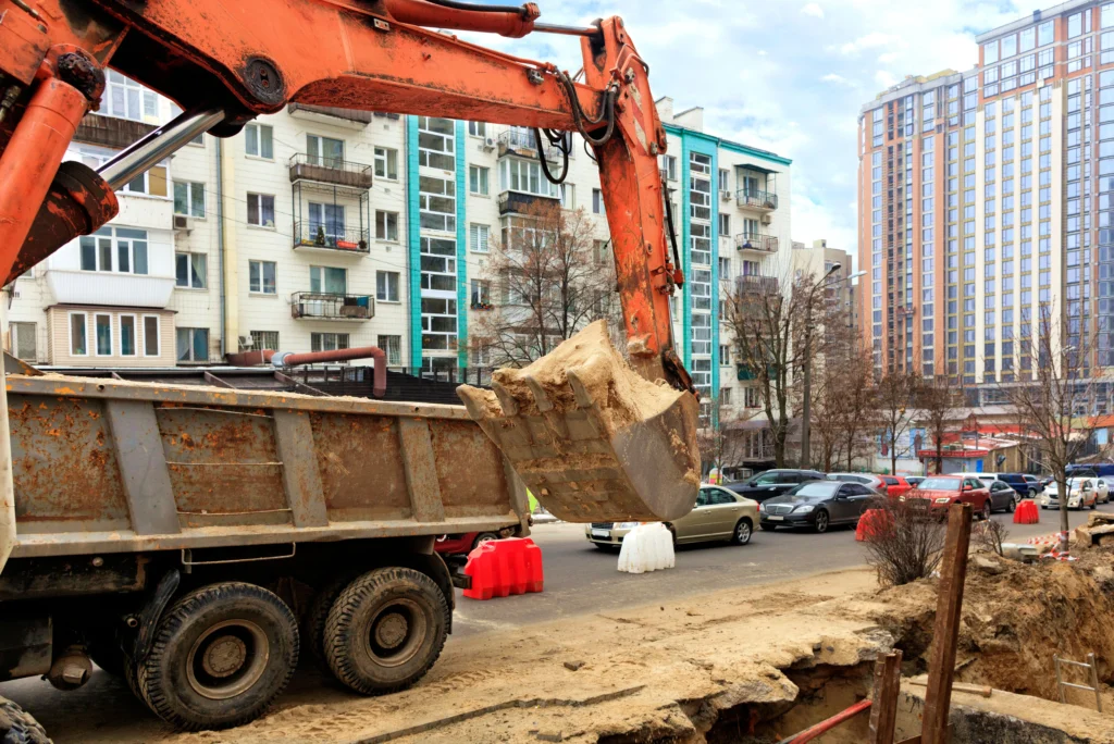Pelleteuse travaillant sur un chantier routier pour le terrassement et la préparation de la chaussée.