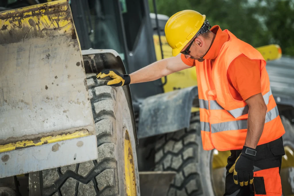 Opérateur vérifiant les équipements de sécurité d'une chargeuse sur chantier