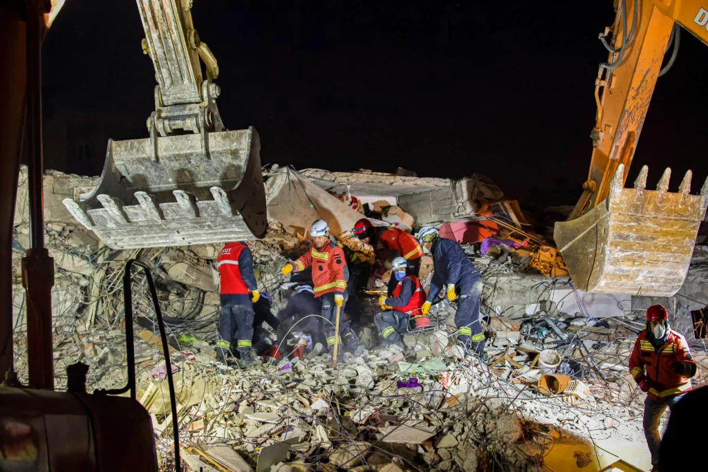 Excavatrice déblayant des débris après une catastrophe naturelle.