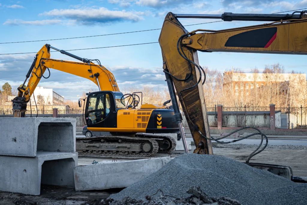 Pelleteuse en action sur un chantier urbain, utilisée pour la démolition et l’excavation entre des bâtiments.